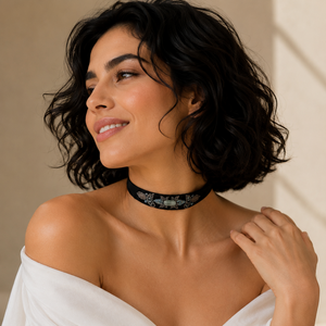 Woman wearing a white off-shoulder garment and a decorative choker necklace.