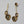 Set of three floral-shaped earrings with gemstones on a white background