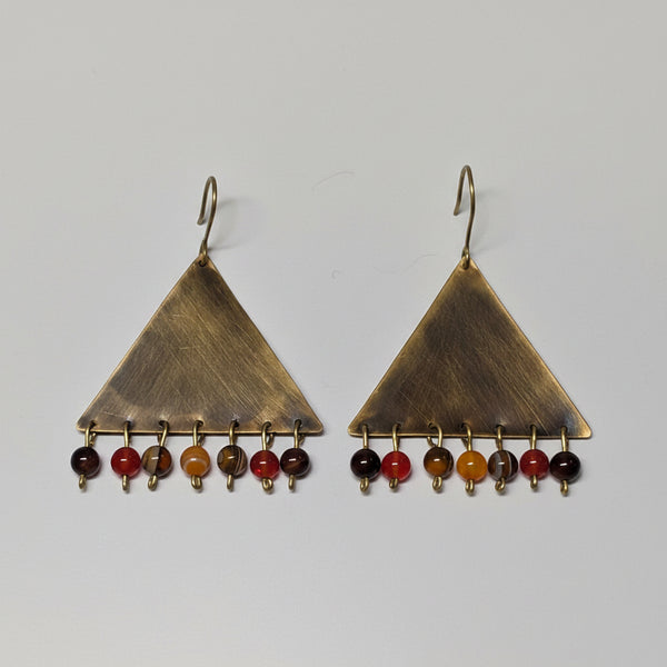 Pair of triangle-shaped earrings with colored beads on a light gray background
